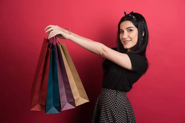 Vrouw Houden Haar Tassen Rode Achtergrond — Stockfoto