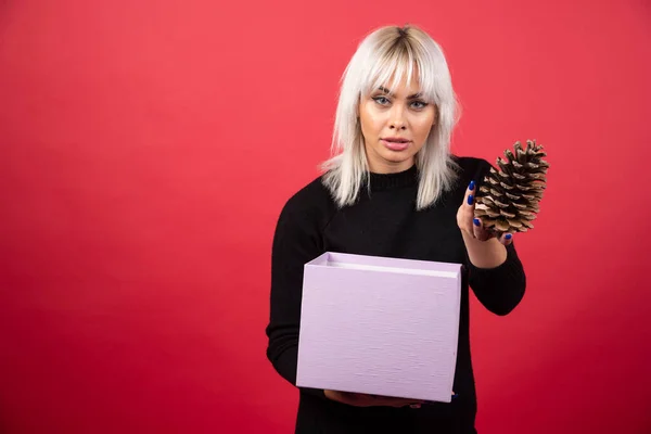 Ung Kvinna Med Presenter Håller Stor Pinecone Röd Bakgrund Högkvalitativt — Stockfoto