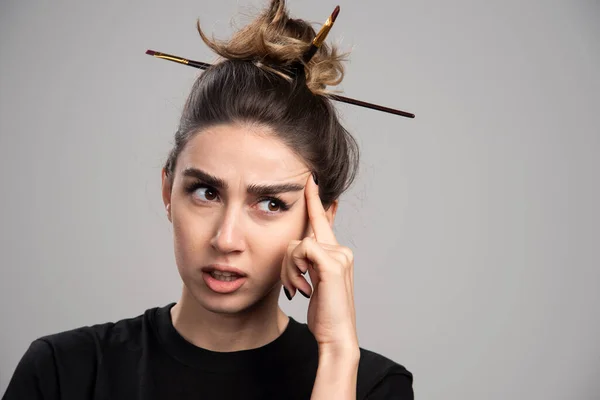 Young woman with messy bun thinking about her plans. High quality photo