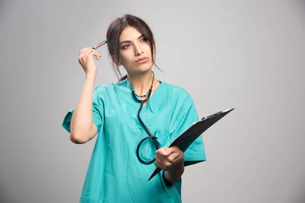 Retrato Doctora Posando Con Portapapeles Sobre Fondo Gris Foto Alta — Foto de Stock