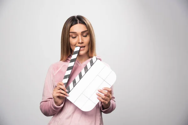 Blond Dametje Roze Sweatshirt Met Een Blanco Klapbord Bijt Een — Stockfoto