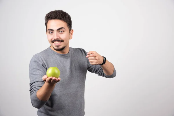 Ung Man Som Håller Grönt Äpple Grå Bakgrund Högkvalitativt Foto — Stockfoto