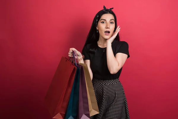 Vrouw Houden Haar Tassen Rode Achtergrond — Stockfoto