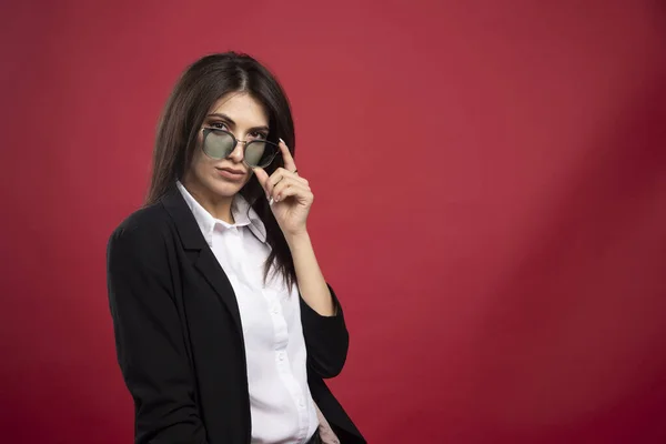 Joven Empresaria Posando Con Gafas Sobre Fondo Rojo Foto Alta —  Fotos de Stock