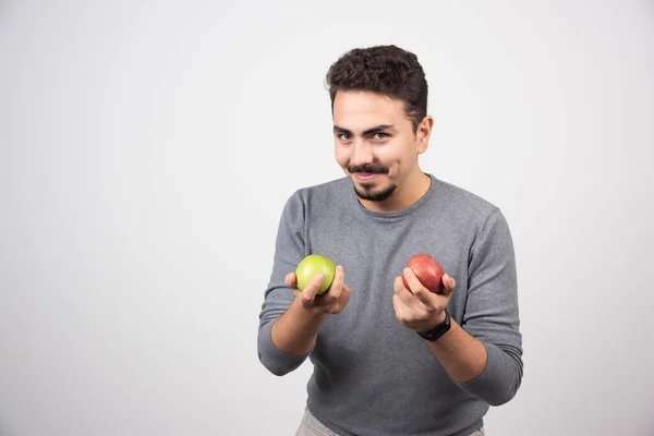 Pohledný Muž Drží Jablka Šedém Pozadí Kvalitní Fotografie — Stock fotografie