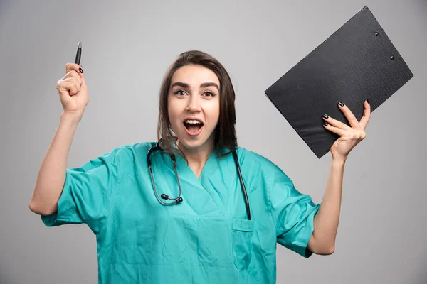 クリップボードを保持しながら制服笑いの女性医師 高品質の写真 — ストック写真