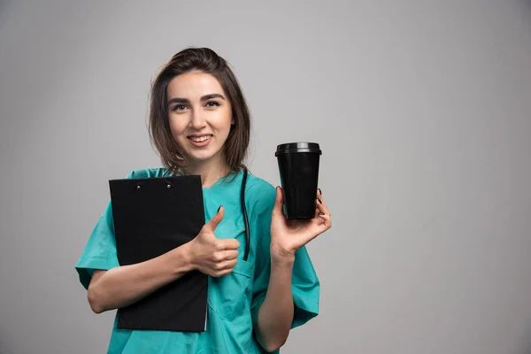 コーヒーカップとクリップボードを保持する女性医師 高品質の写真 — ストック写真