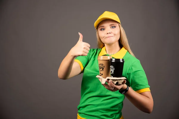 Доставщица Держит Чашки Кофе Показывает Большой Палец Вверх Высокое Качество — стоковое фото