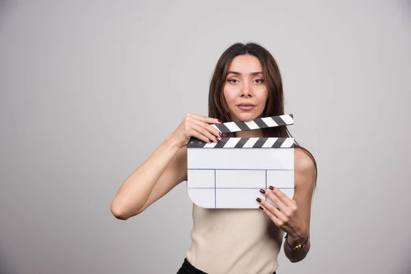 Joven Mujer Sosteniendo Claqueta Sobre Fondo Gris Foto Alta Calidad —  Fotos de Stock