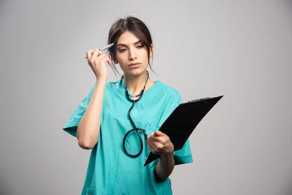 Retrato Doctora Posando Con Portapapeles Sobre Fondo Gris Foto Alta — Foto de Stock