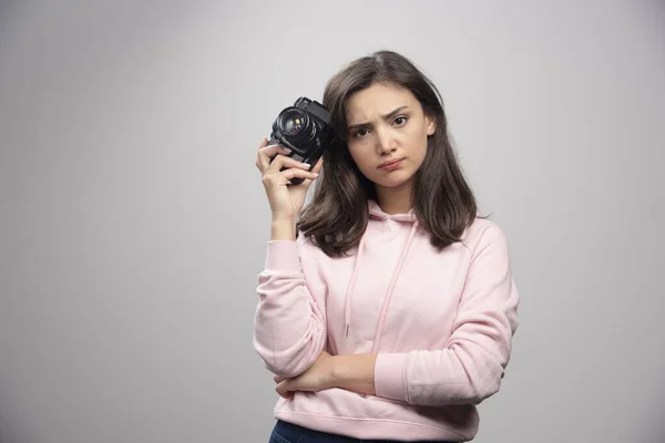 Mladá Žena Růžové Mikině Drží Fotoaparát Zlostně Dívá Kvalitní Fotografie — Stock fotografie