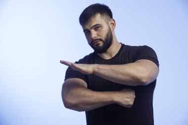 Siyah gömlekli sportif adam kaslarını gösteriyor. Yüksek kalite fotoğraf