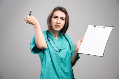 Öfkeli doktor gri arka planda pano tutuyor. Yüksek kalite fotoğraf