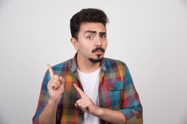 Kafası karışmış genç bir adam parmaklarıyla kenarda duruyor. Yüksek kalite fotoğraf