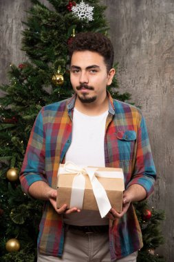Meraklı adam Noel hediyesi olarak elinde tutuyor. Yüksek kalite fotoğraf
