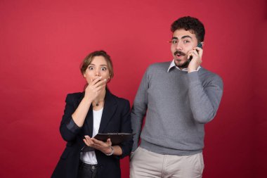 Mutlu adam telefonda konuşuyor ve şok olmuş bir kadının yanında duruyor. Yüksek kalite fotoğraf