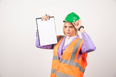 Yeşil başlıklı kadın müteahhit beyaz arka planda pano tutuyor. Yüksek kalite fotoğraf