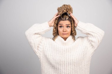 Beyaz örülü süveter giyen genç kadın şaşkın hissediyor. Yüksek kalite fotoğraf