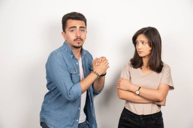 Üzgün adam beyaz arka planda bir kadından özür diliyor. Yüksek kalite fotoğraf