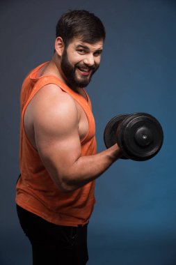 Koyu mavi arka planda dambılı tutan güçlü bir adam. Yüksek kalite fotoğraf