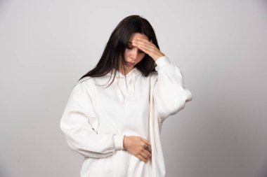 Kafasını tutup stüdyo arka planında poz veren kadın portresi. Yüksek kalite fotoğraf