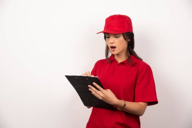 Kırmızı üniformalı ve beyaz arka planda panosu olan genç bir işçi. Yüksek kalite fotoğraf