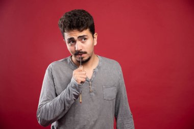 Sanatçı fırçasını kafasına dayayıp yaratıcı fikirleri düşünüyor. Yüksek kalite fotoğraf