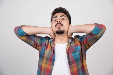 Beyaz arka planda sakallı ve gömlekli genç bir adam.