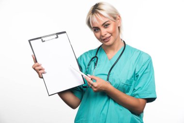 Gülümseyen kadın doktor beyaz arka planda kalemle panoyu işaret ediyor. Yüksek kalite fotoğraf