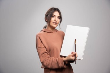 Elinde fırça ve tuval tutan güzel bir sanatçı. Yüksek kalite fotoğraf