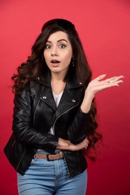 Kırmızı arka planda siyah gözlüklü genç bir kadın. Yüksek kalite fotoğraf