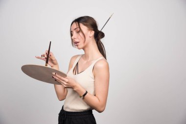 Palet boyamaktan renk alan genç bir ressam. Yüksek kalite fotoğraf