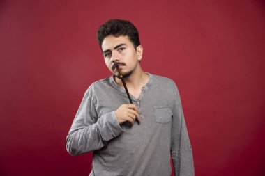 Sanatçı fırçasını kafasına dayayıp yaratıcı fikirleri düşünüyor. Yüksek kalite fotoğraf