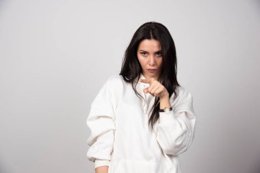 İşaret parmağıyla işaret eden ciddi bir genç kadının portresi. Yüksek kalite fotoğraf