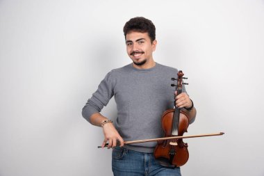 Müzisyen keman çalar, ilham verici ve pozitif görünür. Yüksek kalite fotoğraf