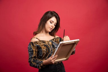 Ressam kız tuvale pozitif enerjiyle resim yapıyor. Yüksek kalite fotoğraf