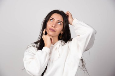 Düşünceli genç bir kadının portresi ayakta dikilip başka tarafa bakıyor. Yüksek kalite fotoğraf