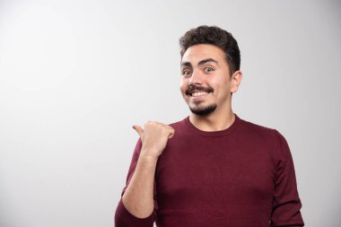 Parmağını gösterip poz veren mutlu esmer bir adam. Yüksek kalite fotoğraf