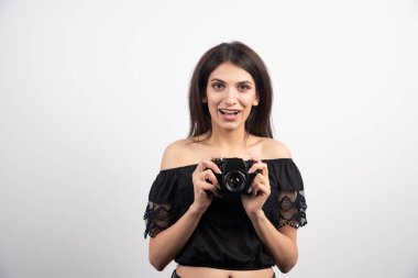 Beyaz arka planda kamerayla poz veren güzel bir kadın. Yüksek kalite fotoğraf