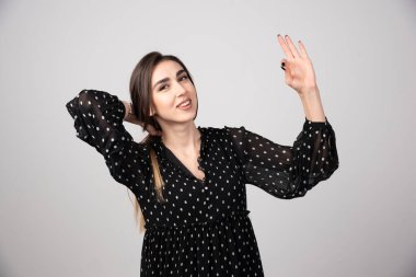 Ayakta duran ve işaret parmaklarıyla işaret eden güzel bir genç kadının portresi. Yüksek kalite fotoğraf