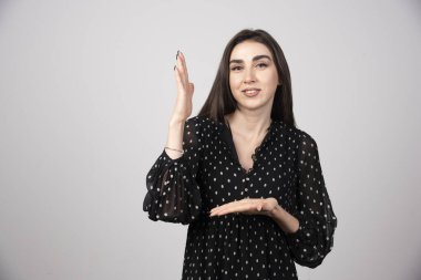 Gri arka planda açık alan tutan kadın portresi. Yüksek kalite fotoğraf