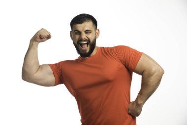 Kırmızı gömlekli sporcu kol kaslarını gösteriyor ve bağırıyor. Yüksek kalite fotoğraf