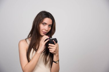 Gri arka planda kamera pozu veren güzel bir kadın. Yüksek kalite fotoğraf