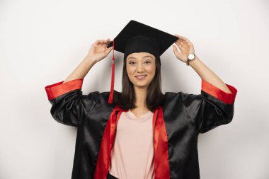 Önlüklü, beyaz arka planda poz veren mutlu lisans öğrencisi. Yüksek kalite fotoğraf