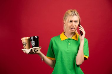 Kahveli kadın kurye telefonda öfkeyle konuşuyor. Yüksek kalite fotoğraf