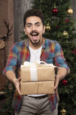 Gülümseyen yakışıklı adam Noel hediyeleri taşıyor. Yüksek kalite fotoğraf