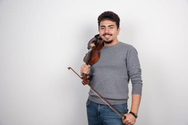 Müzisyen keman çalar, ilham verici ve pozitif görünür. Yüksek kalite fotoğraf