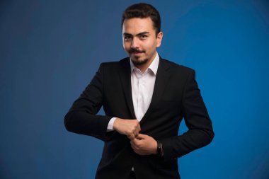 Siyah takım elbiseli iş adamı ceketinin düğmelerini ilikliyor. Yüksek kalite fotoğraf