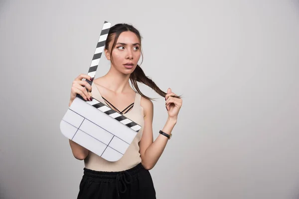 Mujer Camisa Beige Sosteniendo Clapperboard Jugando Con Pelo Foto Alta — Foto de Stock