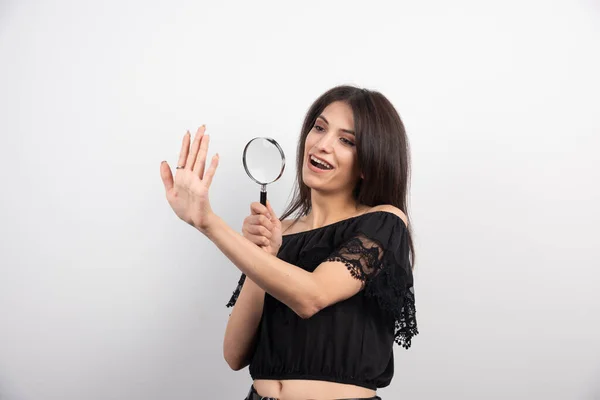 Brunette Vrouw Kijkt Naar Haar Hand Met Vergrootglas Een Witte — Stockfoto